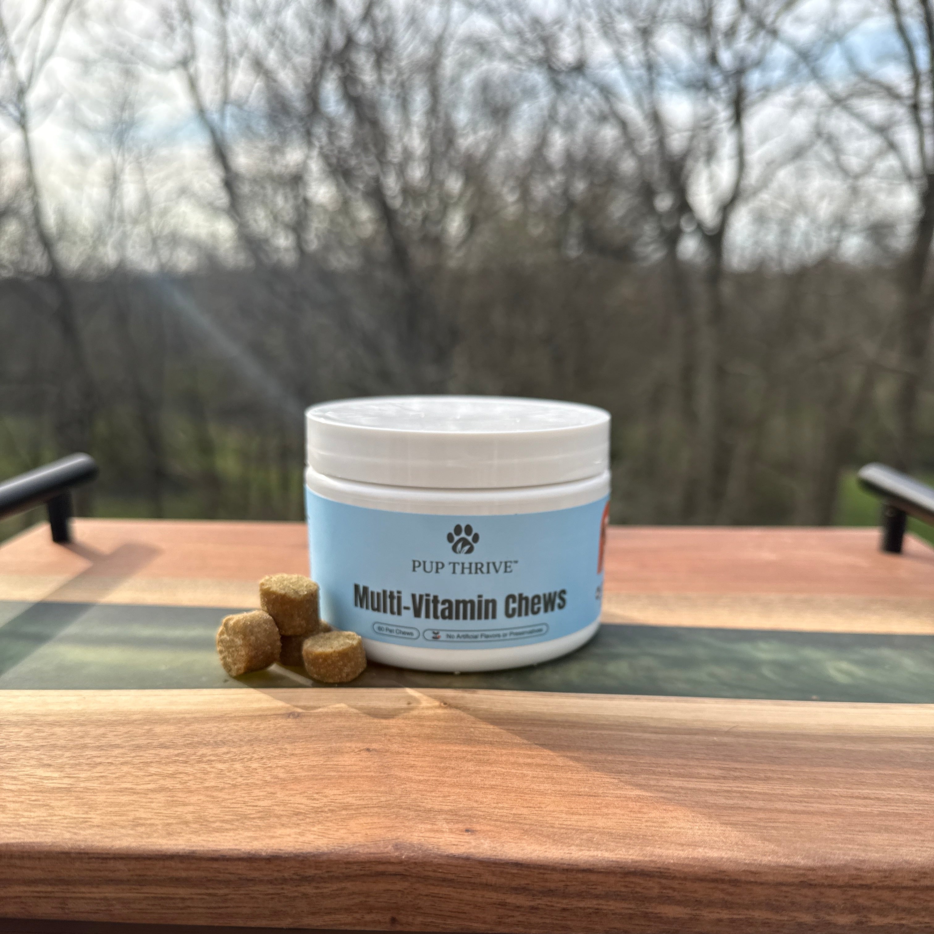 Container of Multii-Vitamin Chews on a wooden surface with a blurred outdoor background